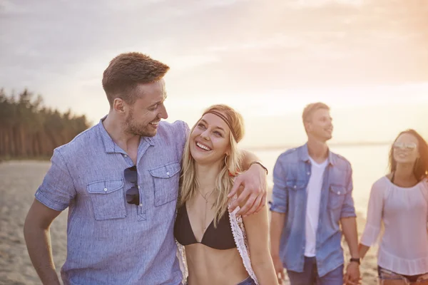 Couples sur la plage au coucher du soleil — Photo