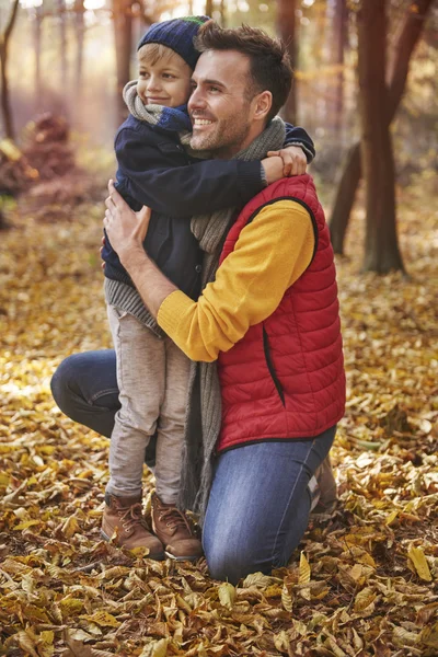 Pai abraçando seu filho na floresta — Fotografia de Stock