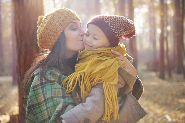 Mother kissing and hugging her little daughter — Stock Photo, Image