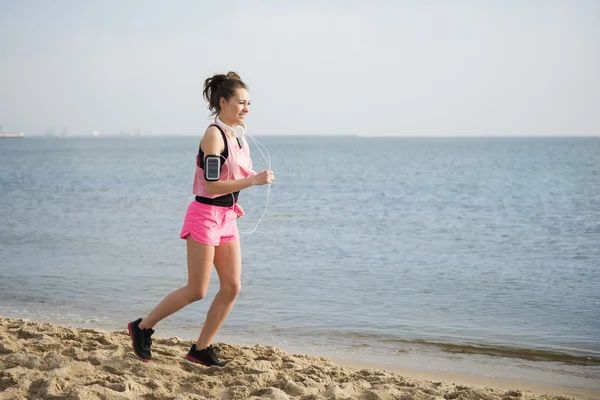 Donna che corre attraverso la spiaggia — Foto Stock
