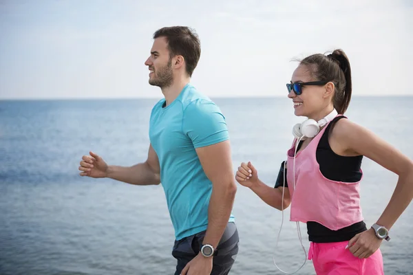 Giovane coppia che corre vicino all'oceano — Foto Stock