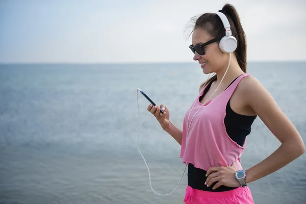 Mujer escuchando música desde el teléfono móvil —  Fotos de Stock