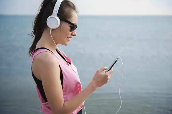 Femme écoutant de la musique du téléphone intelligent — Photo