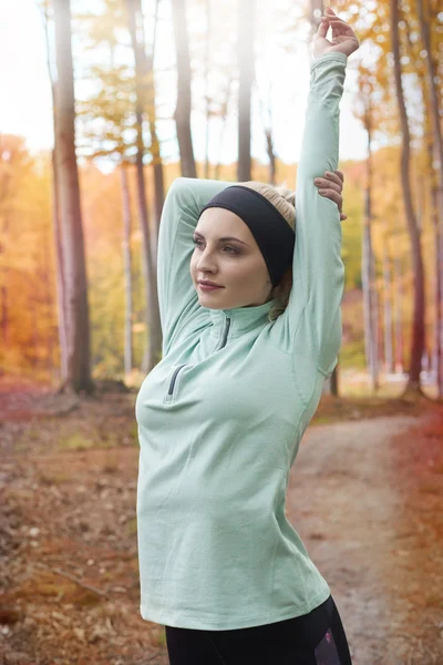 Vrouw die zich uitstrekt voordat dagelijks hard joggen — Stockfoto