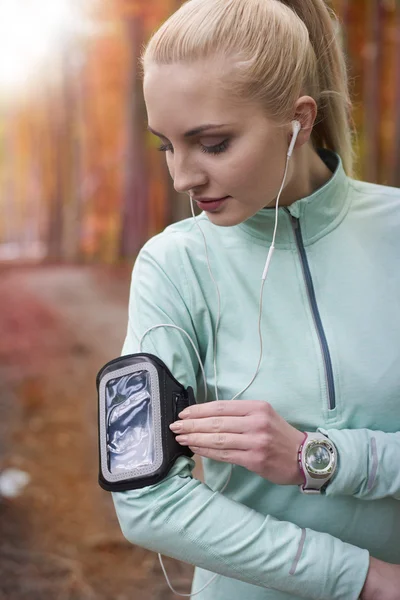 Wanita mendengarkan musik selama jogging — Stok Foto