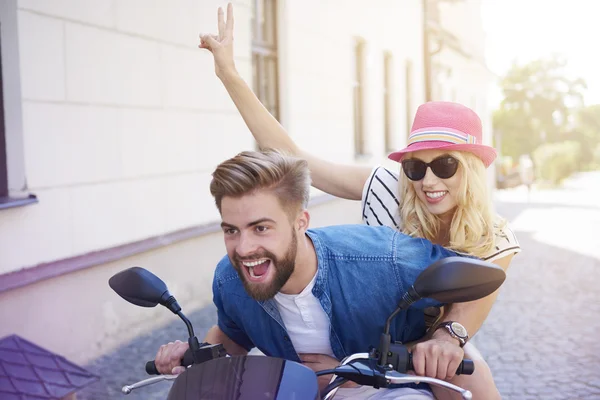 Paar fährt mit Motorroller durch die Stadt — Stockfoto