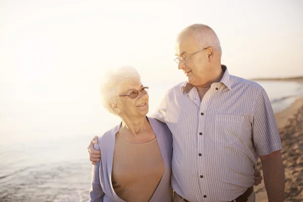 Senior paar lopen over het strand — Stockfoto