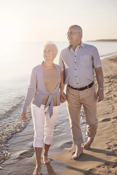 Senior paar lopen over het strand — Stockfoto