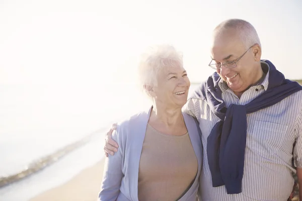 Couple aîné marchant sur la plage — Photo