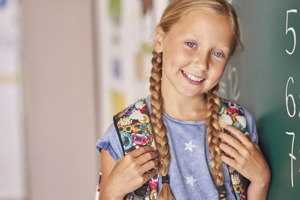 Blonde haren meisje naast het schoolbord — Stockfoto