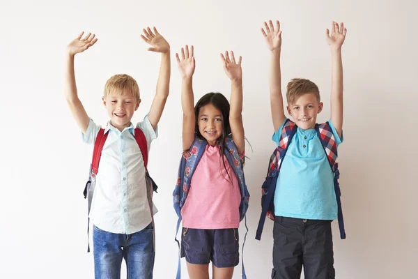 Children with raised hands looking at camera — Stock Photo, Image