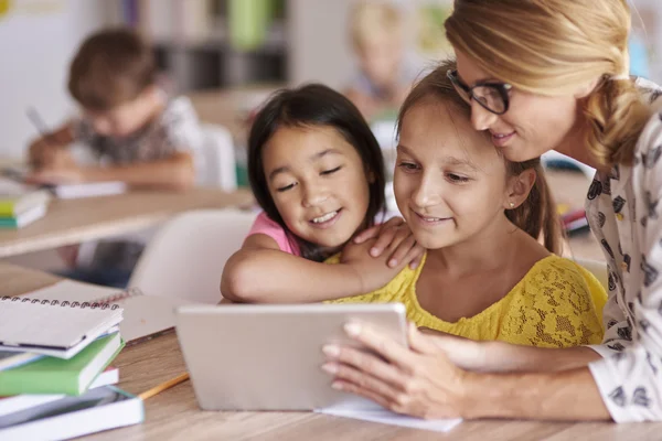 Enseignant aidant les élèves avec une tablette numérique — Photo