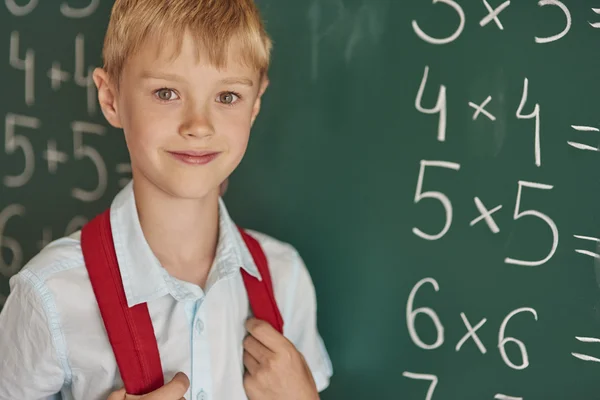 Pojken står bredvid tavlan — Stockfoto