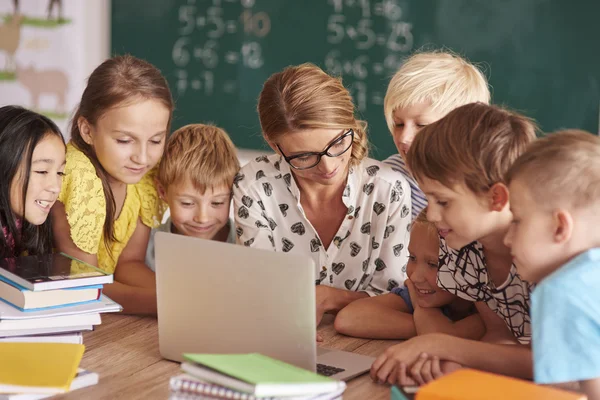 Teamwork over the teacher's laptop — Stock Photo, Image