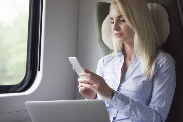 Empresária trabalhando com telefone celular e laptop — Fotografia de Stock