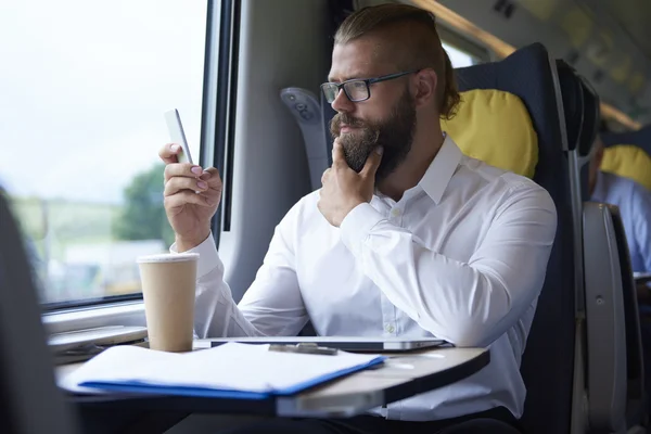 Biznesmen patrząc na telefon komórkowy — Zdjęcie stockowe