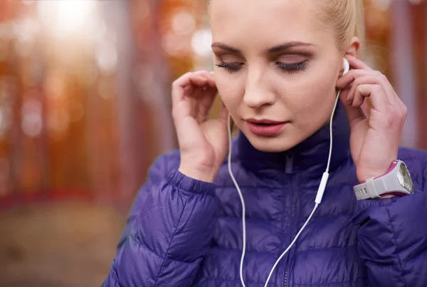 Vrouw zettend oortelefoons alvorens het joggen — Stockfoto