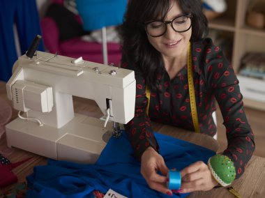 Dikiş makinesinin üzerinde çalışan moda tasarımcısı 