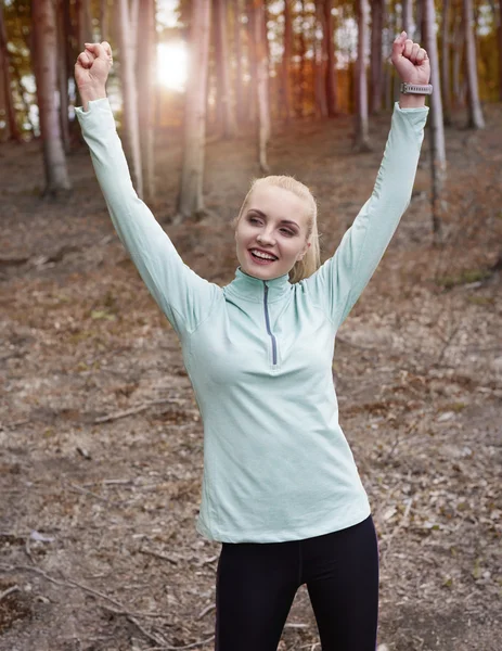 Lycklig kvinna som står med upphöjda händer — Stockfoto