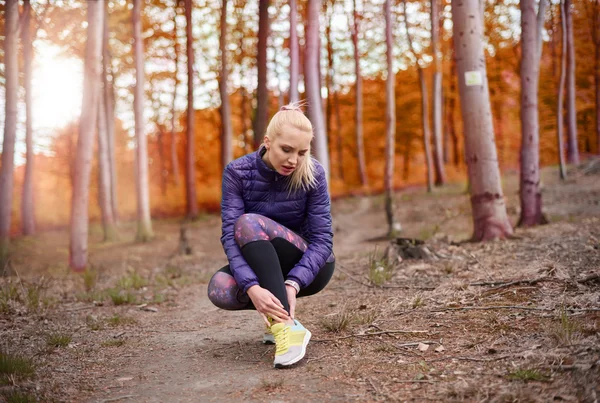 Sportif kadın sonbahar ormanda çalışan — Stok fotoğraf