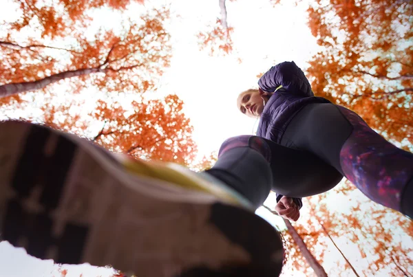 Sportif kadın sonbahar ormanda çalışan — Stok fotoğraf