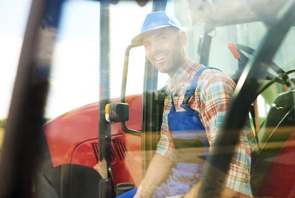 Agricultor sentado en las escaleras del tractor — Foto de Stock