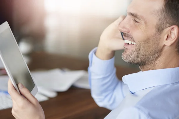 Met behulp van digitale tablet en praten over de telefoon — Stockfoto