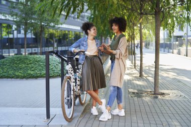 Şehirdeki bir toplantıda konuşan iki odaklı kadın.                               