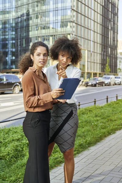 Dwie Bizneswoman Cyfrowym Tabletem Wskazujące Coś Mieście — Zdjęcie stockowe