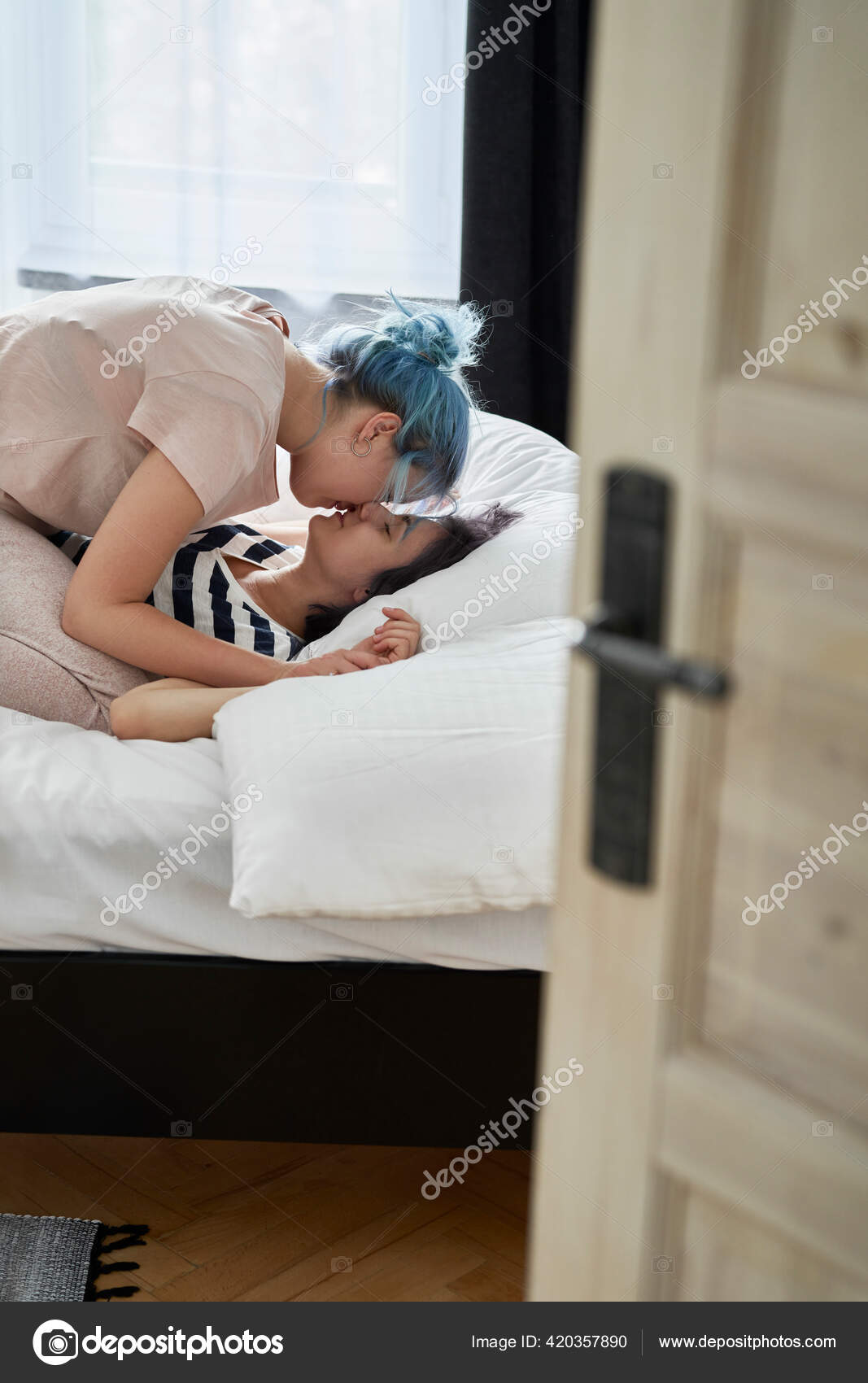 Lesbian women with lollipop kissing in bed. Lesbian women with lollipop kissing in bed.