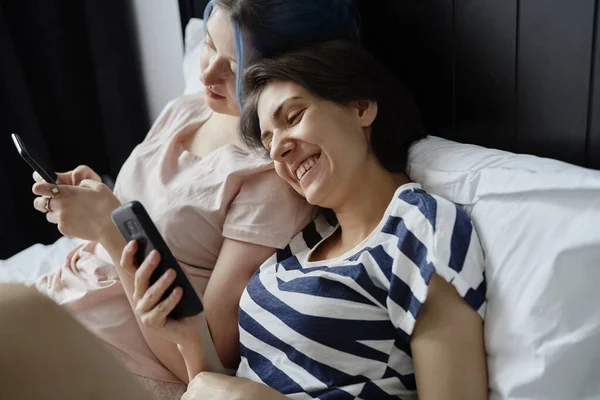Boldog Leszbikus Pár Feküdt Ágyban Mobiltelefonnal — Stock Fotó