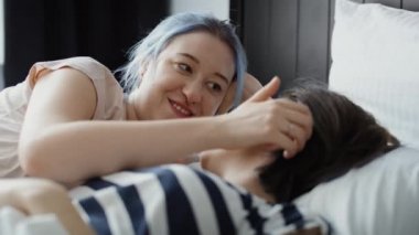 Lezbiyen çiftin yatakta sevgi dolu konuşmalarının ve öpüşmelerinin videosu. 8K 'da kırmızı helyum kamerayla çekildi.