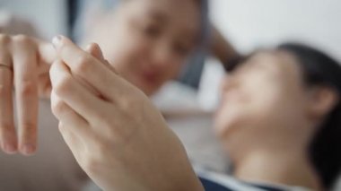 Yatakta el ele tutuşan lezbiyen çiftin videosunu kapat. 8K 'da kırmızı helyum kamerayla çekildi..