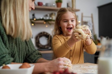 Küçük kız pasta yaparken eğleniyor.                               