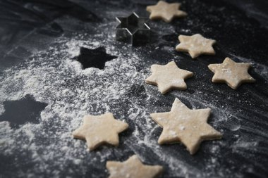 Siyah arka planda çiğ Noel kurabiyelerini kapat