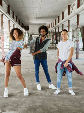 Harabelerde dans eden üç mutlu genç.                               