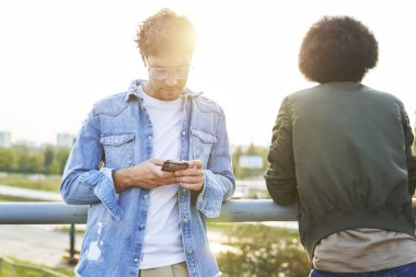 Ayakta duran ve cep telefonu kullanan adam                               