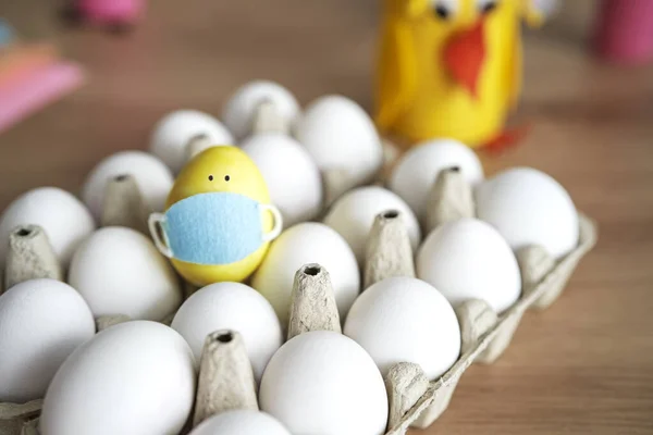 Close up of eggs and one egg with protective face mask