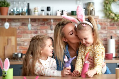 Paskalya eğlencesinde kızlarıyla güzel bir anne öpücüğü.                               