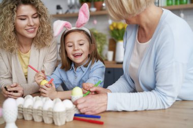 Mutlu aile evde paskalya yumurtası süsler.                               