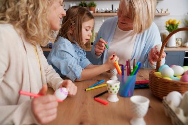 Paskalya yumurtalarını birleştirirken üç kuşak kadın.                               