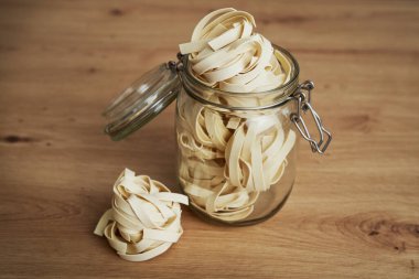 Mutfak tezgahındaki çiğ tagliatelle dolu kavanozu kapat.                               