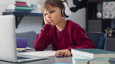 Evde ders çalışırken sıkılmış çocuğun el kamerasıyla çekilmiş videosu. 8K 'da kırmızı helyum kamerayla çekildi..