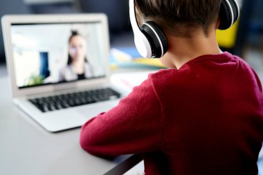 Çevrimiçi dersler sırasında çocuğun arka görünümü                               