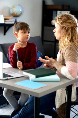 Anne ve oğul evde birlikte okuyorlar.