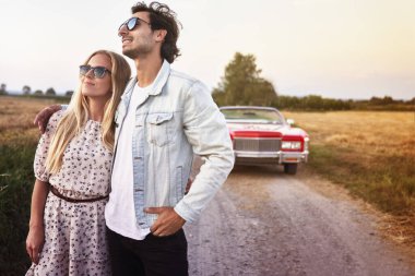 Çift gün batımını izlerken sarılıyor.                               