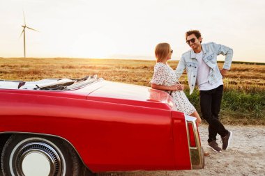 Yakışıklı bir adam araba yolculuğu sırasında bir kadına kur yapıyor.                               