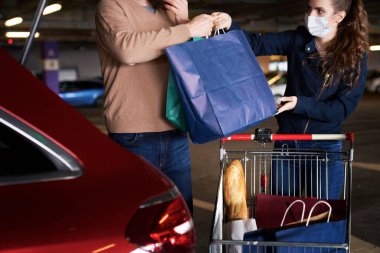 Alışveriş çantalarını bir arabanın bagajına koy.                               