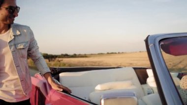 Cabriolet 'e atlayan mutlu bir adamın videosu. 8K 'da kırmızı helyum kamerayla çekildi..