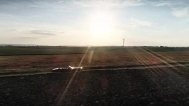 Kırmızı araba yaz günbatımında kır yolundan gidiyor. 8K 'da kırmızı helyum kamerayla çekildi.